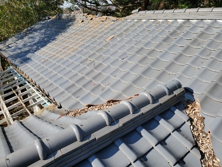 棟瓦周辺に堆積した落葉と崩れた瓦の確認