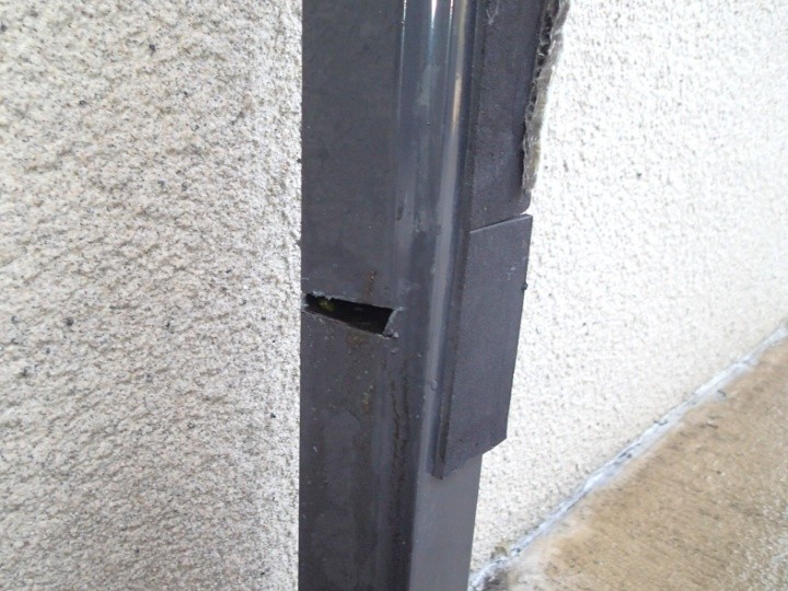 竪樋の途中に開いた開口部と漏水痕