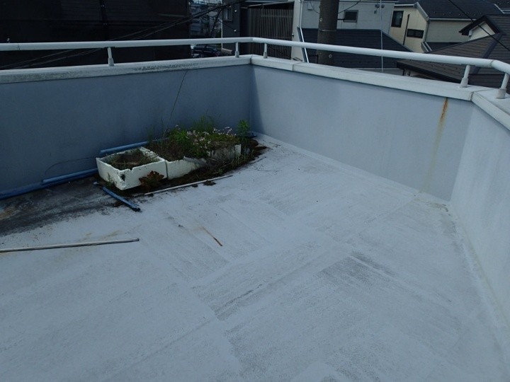 陸屋根の床面に汚れと堆積物が見られる