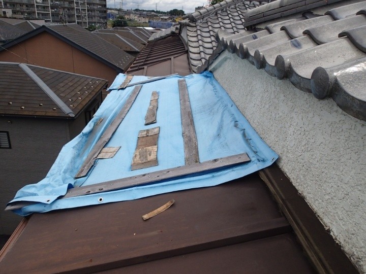 ブルーシートで養生された庇屋根